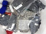 a pile of clothes that is sitting on a bed