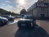 a black car parked in a parking lot next to a building