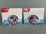 two boxes of pokemon trading cards are sitting on a table