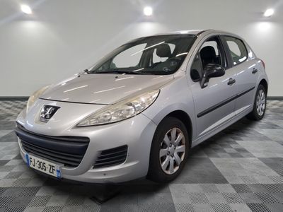 La petite voiture argentée est garée dans le garage, sur le sol à damier.