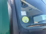 a green truck with a yellow sticker on it ' s windshield