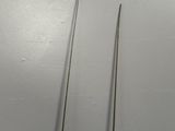 two needles are sitting on a white surface next to each other