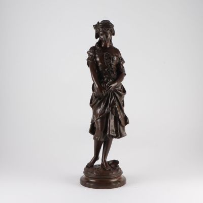 a bronze statue of a man in a dress and hat