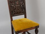 une vieille chaise en bois avec une assise en velours jaune et un dossier sculpté