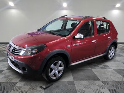 une photo d'une Dacia rouge garée sur un sol à damier