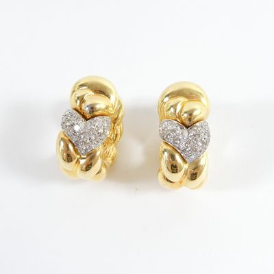 une paire de boucles d'oreilles en or jaune et diamants sur fond blanc