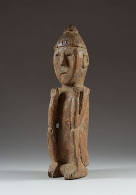 une statue en bois d'un homme avec un chapeau sur la tête
