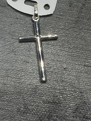 une croix posée par terre à côté d'une paire de ciseaux