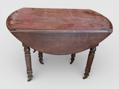 TABLE A VOLETS en bois, 6 pieds tournés à roulettes.