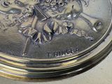 a silver clock with a picture of a girl and a horse on it