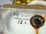 a close up of a gold and white vase with writing on it