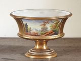 un plateau en or orné d'une peinture, posé sur une table