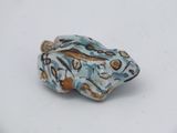 a small blue and brown bead on a white surface