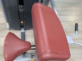 a close up of a red seat on a gym machine