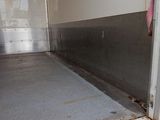 a dirty floor in a room with a door open