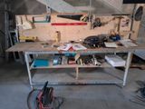 un établi dans un garage, sur lequel sont posés de nombreux outils