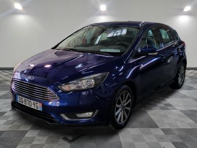 the blue car is parked on a checkered floor in the garage