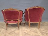 pair of red velvet chairs with carved wood arms and legs