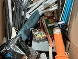 a cardboard box filled with assorted items like tennis racquets, tennis balls, tennis rackets, tennis balls, tennis rackets, and