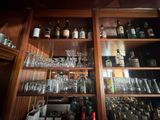 many glasses and bottles on the shelves in the bar