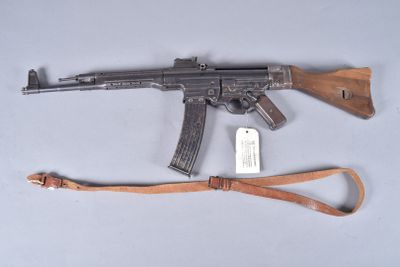 an ak - 47 machine gun with a leather sling on a white surface