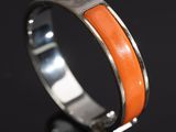 a close up of a ring with an orange stone in it