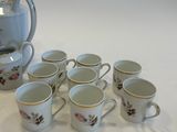 six cups and a teapot sitting on a table