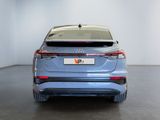 the rear end of a blue car in a white room