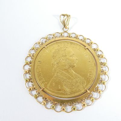 une image représentant un pendentif en forme de pièce d'or orné du portrait d'une femme