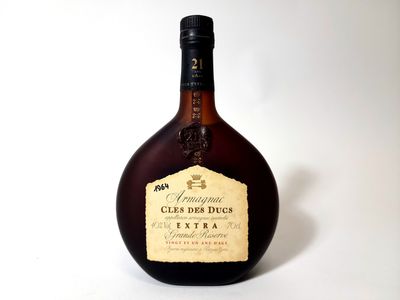 an old bottle of liquor sitting on a white surface