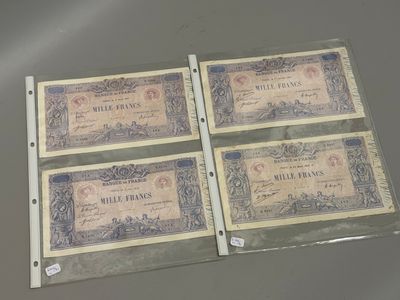 trois vieux billets de banque français posés sur une table