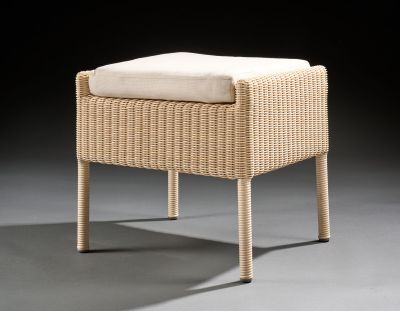 an upholstered wicker stool with a cushion on top of it