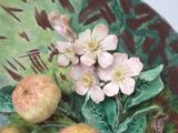 a plate with fruit and flowers on it on a table
