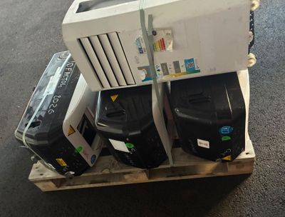 une pile de bagages posée sur une palette au sol