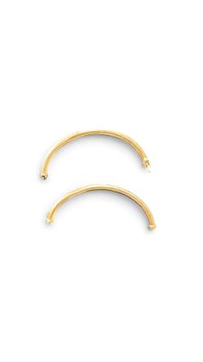 a pair of gold hoop earrings on a white background