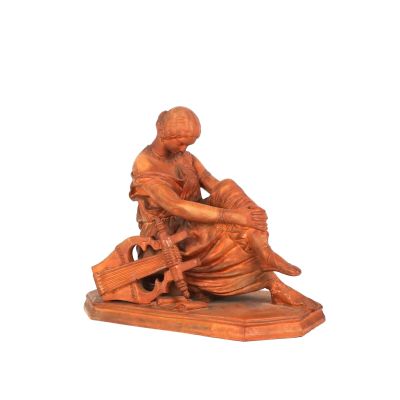 statue représentant une femme assise sur un banc, tenant un panier de fleurs