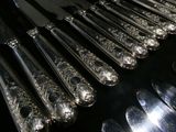 a lot of silver spoons and knives on the table