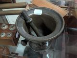 a glass display case with a mortar and other items on it