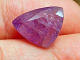 Quelqu'un tient dans sa main une très jolie pierre violette.