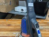 un aspirateur posé sur une table en bois