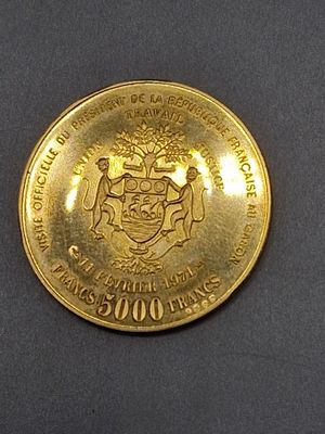 une pièce d'or sur laquelle figurent des armoiries et un blason