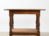 an old wooden table with a shelf on top of it