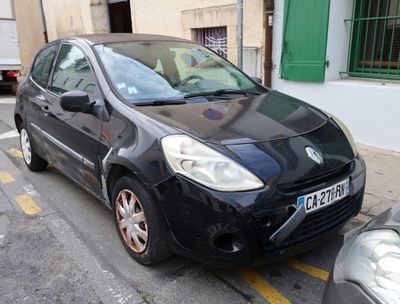 a small black car parked on the side of the street