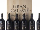 six bottles of gran calesse are lined up in front of a wooden box