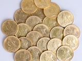 a pile of gold coins sitting on a white surface