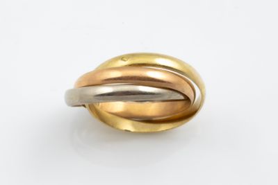 gros plan d'une bague en or et en argent sur une surface blanche