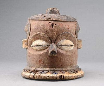 une image d'un masque en bois sur un support