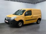 La camionnette jaune est garée dans une grande pièce aux murs blancs.