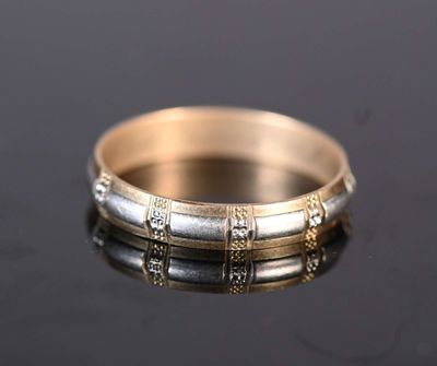 a close up of a gold and silver ring on a black surface