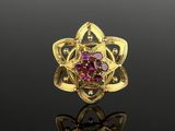 une image représentant une bague en or sertie de pierres roses sur un fond noir